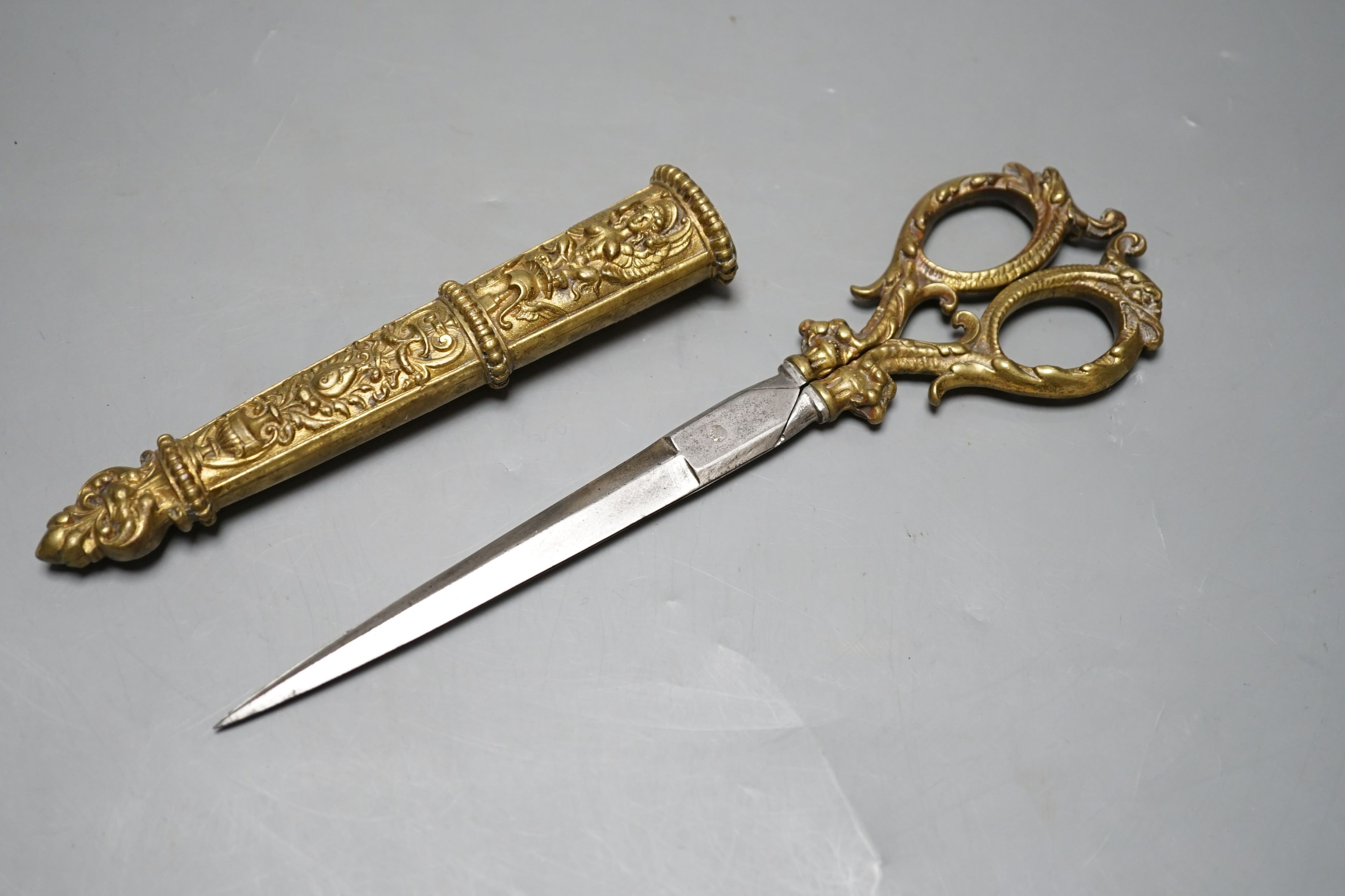 A pair of embossed brass scissors and cover